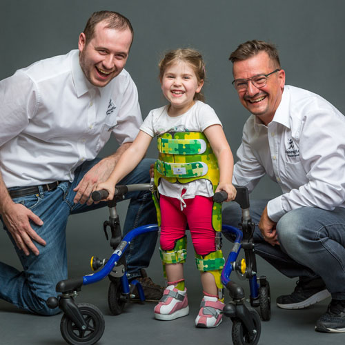 Kind freut sich gemeinsam mit Mitarbeitern der Nonnengäßer Orthopädietechnik Göppingen über seine neue Gehorthese.