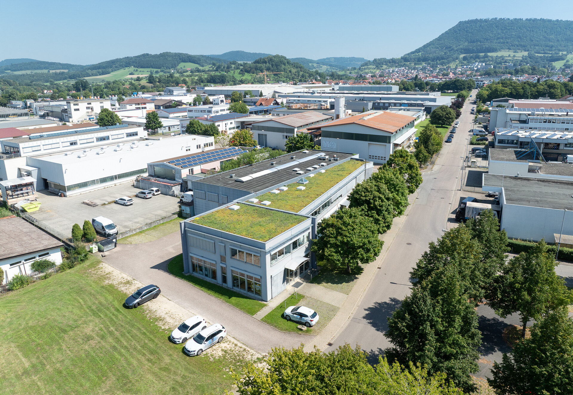 Das Gebäude der Nonnengäßer Orthopädietechnik GmbH aus der Vogelperspektive mit Parkplatz, Dachbegrünung und umstehenden Gebäuden